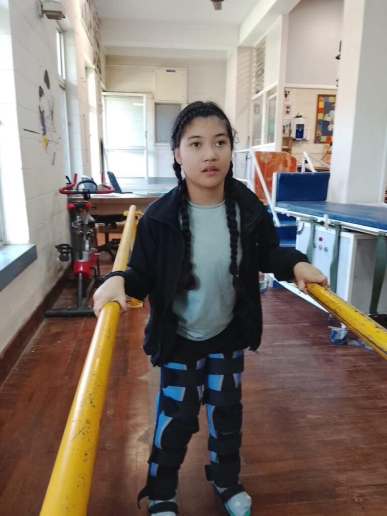 A girl practising walking with support rails